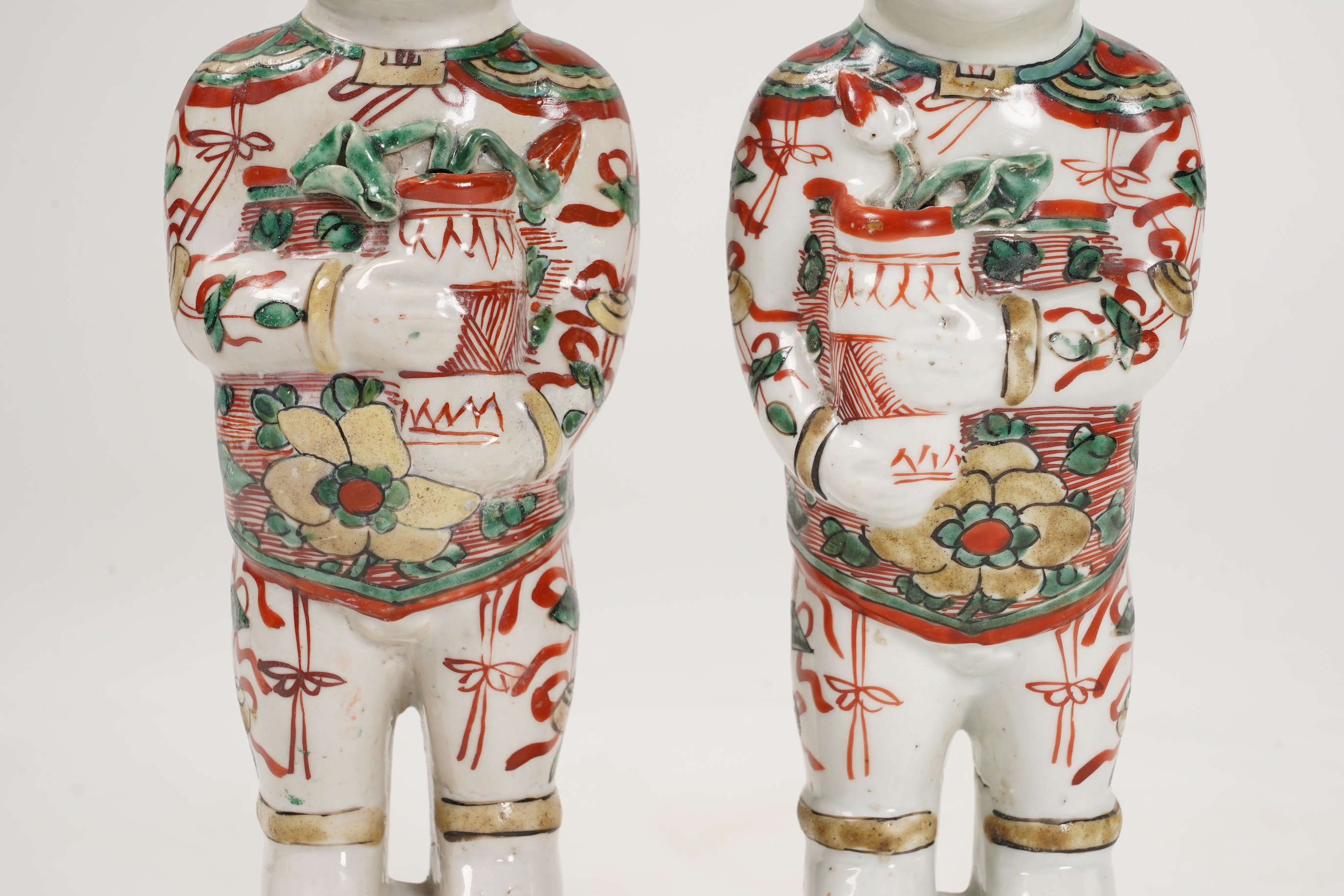 A pair of Chinese famille verte figures of smiling boys, Kangxi period